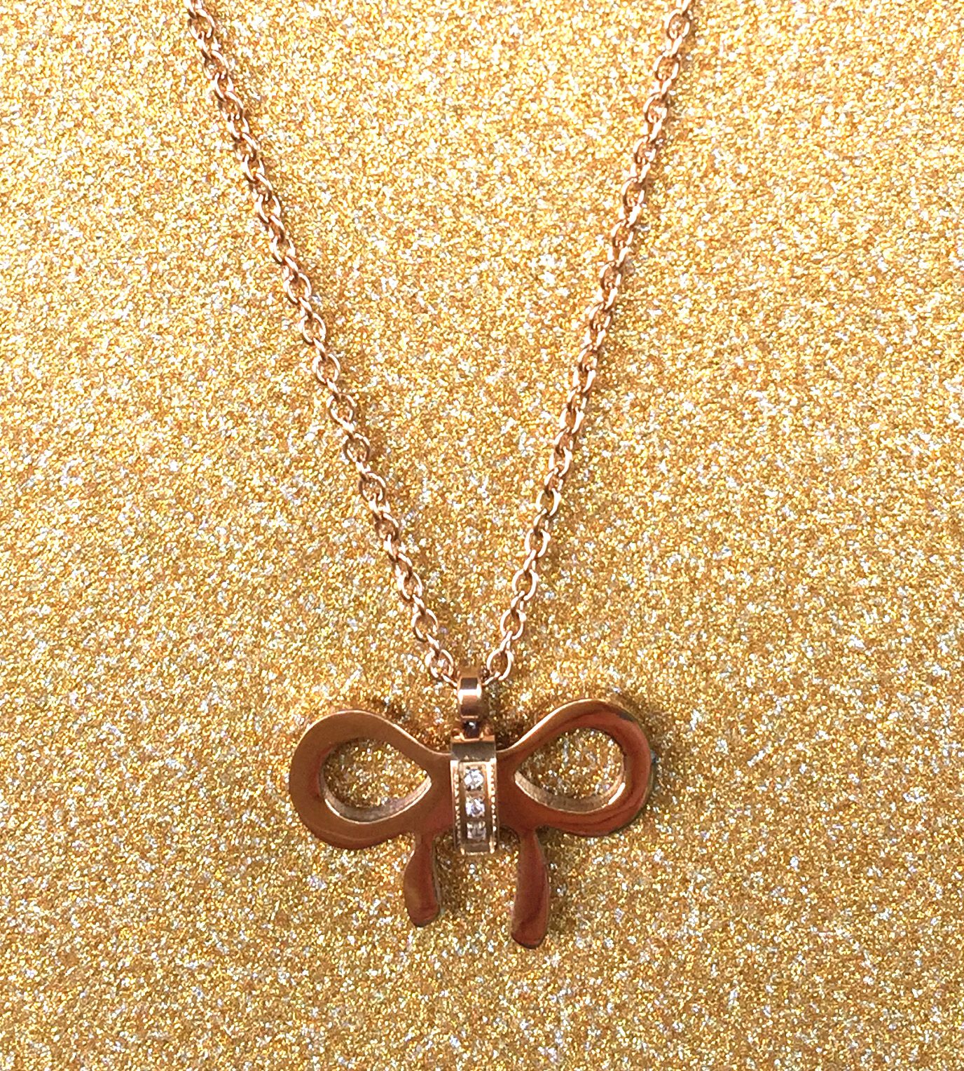 A beautiful butterfly pendant made of mother of pearl and emblazoned with small glittering crystals on a gold metal base. J020010